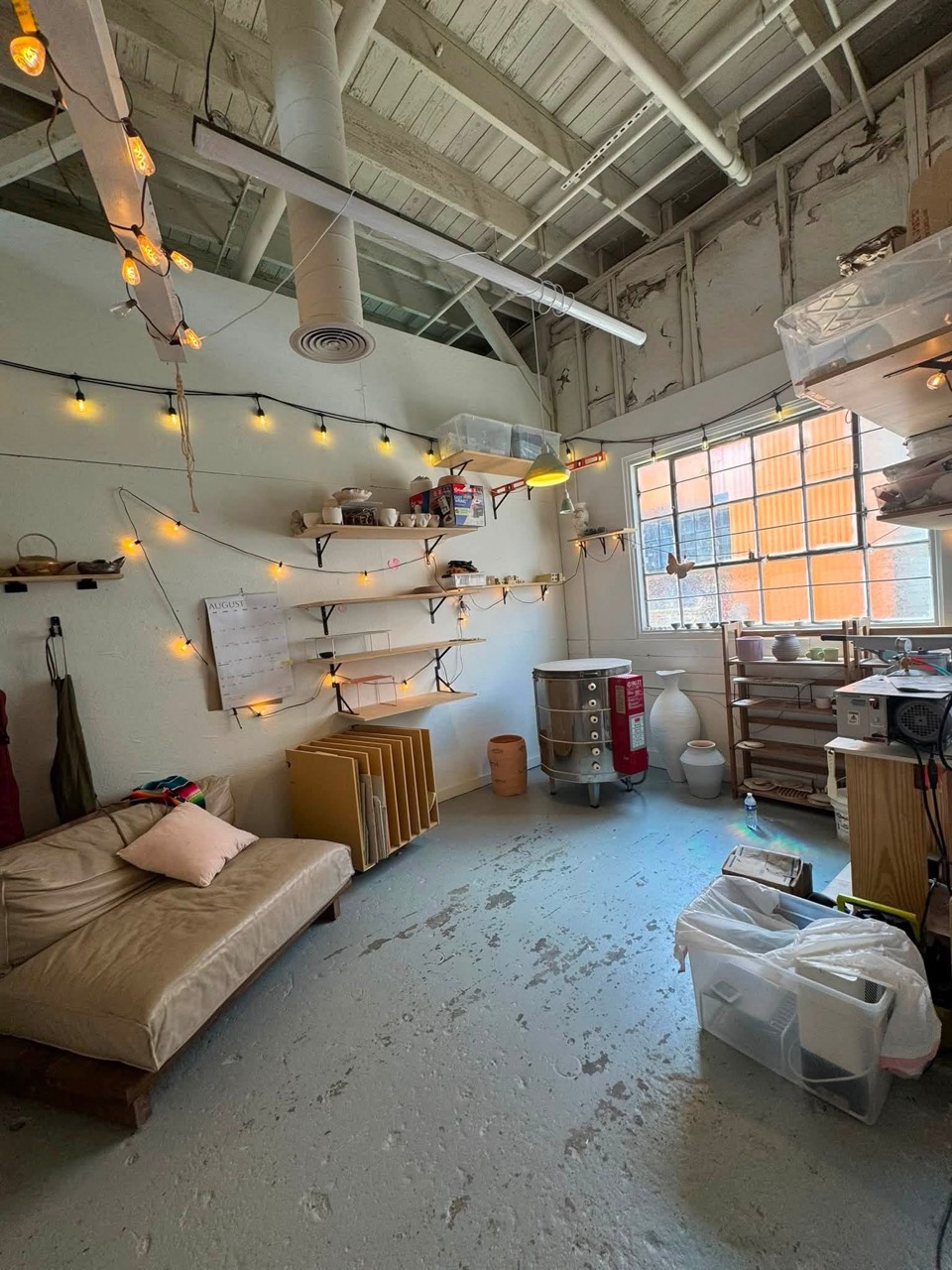 Kiln corner with member shelving, studio storage, and a lounge area